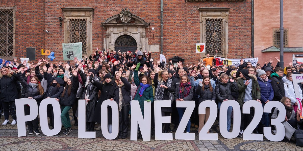 Uczestnicy Poloneza dla Fredry 2023 we wrocławskim Rynku. Z przodu napis "Polonez 2023"