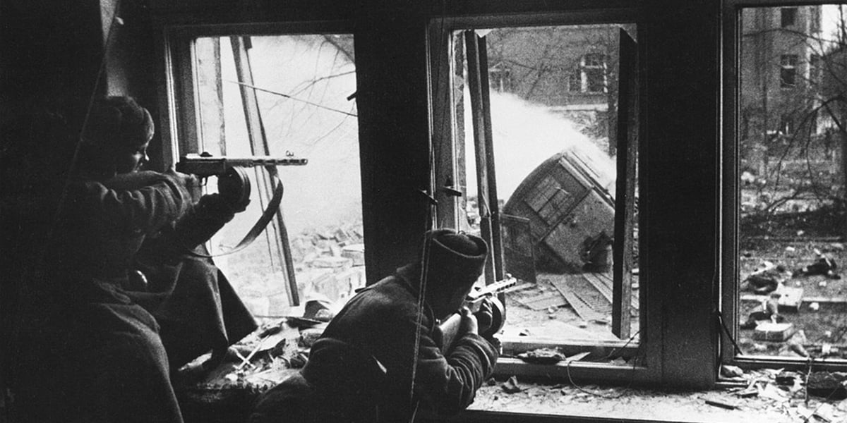 Dwóch żołnierzy Armii Czerwonej na stanowiskach strzeleckich w wybitych oknach kamienicy, Wrocław 1945 rok.