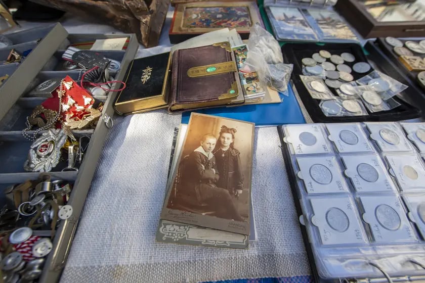 Na zdjęciu zabytkowe rzeczy wystawione na sprzedaż. Na pierwszym planie stara fotografia, na której są chłopiec i dziewczynka 