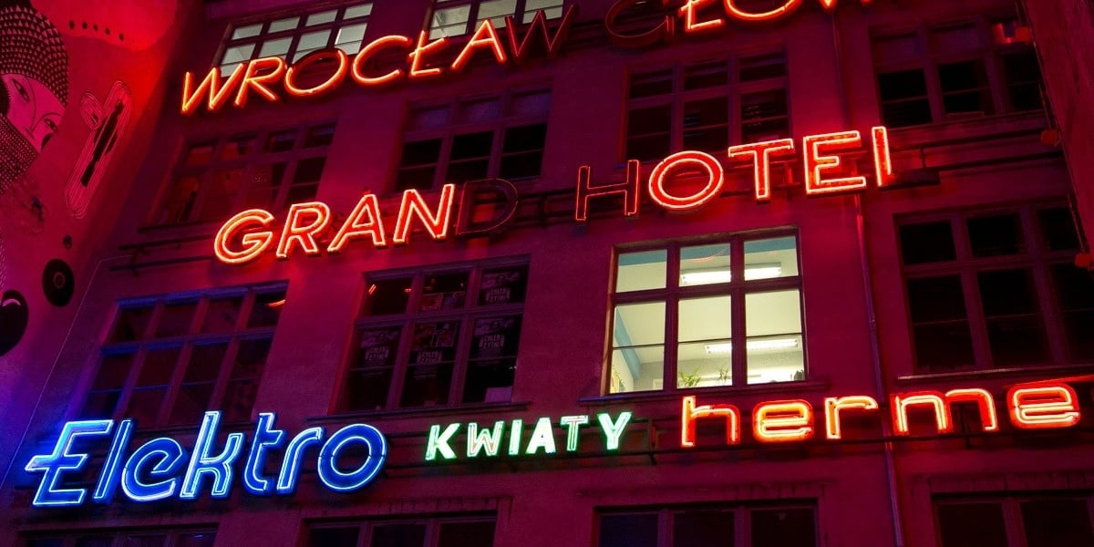 Wrocławskie neony. Na zdjęciu widać neony umieszczone na ścianie kamienicy przy ul. Ruskiej 46. Napisy: Elektro, kwiaty, Hermes, Grand Hotel, Wrocław Główny