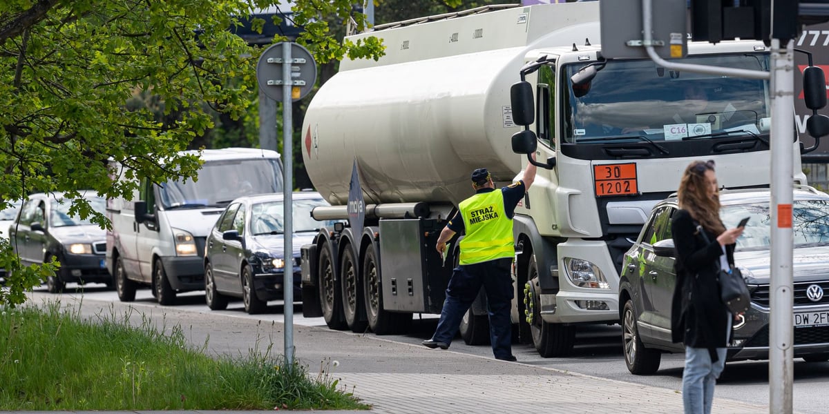 Strażnik miejski rozdaje ulotki, z której kierowcy mogą dowiedzieć się o wprowadzanym objeździe. 