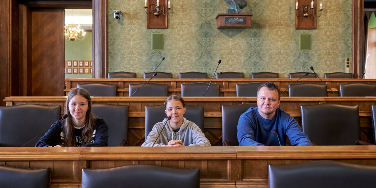 Trzyosobowa rodzina w sali sesyjnej Rady Miejskiej Wrocławia. Dzień Samorządu Terytorialnego, drzwi otwarte we wrocławskich Sukiennicach, 27.05.2023.