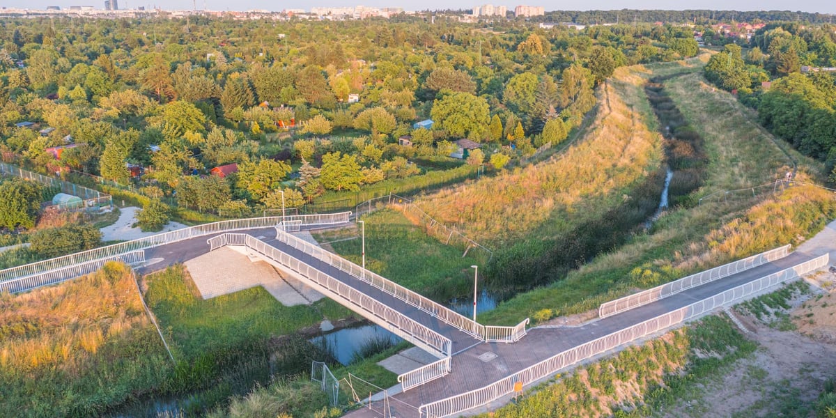 Nowa kładka pieszo-rowerowa nad rzeką w otoczeniu zieleni