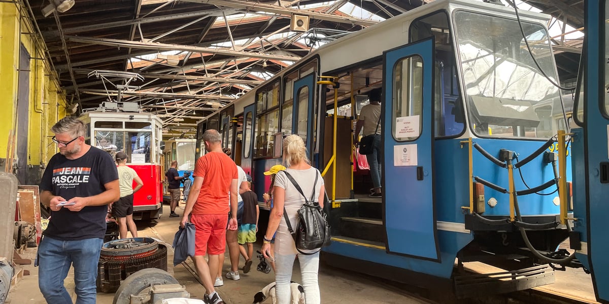Zajezdnia Popowice. Z prawej niebieski tramwaj, obok grupa zwiedzających 