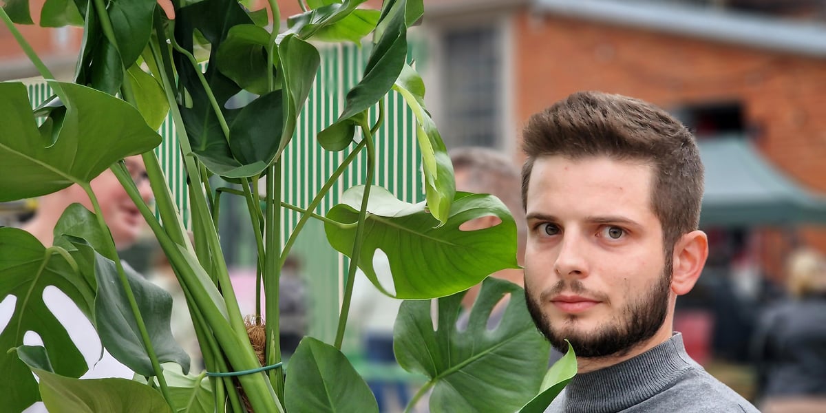 Festiwal roślin doniczkowych. Na zdjęciu Kacper Kuszaj, który kupił tam okazałą monsterę. W tle zabudowania dawnej zajezdni tramwajowej