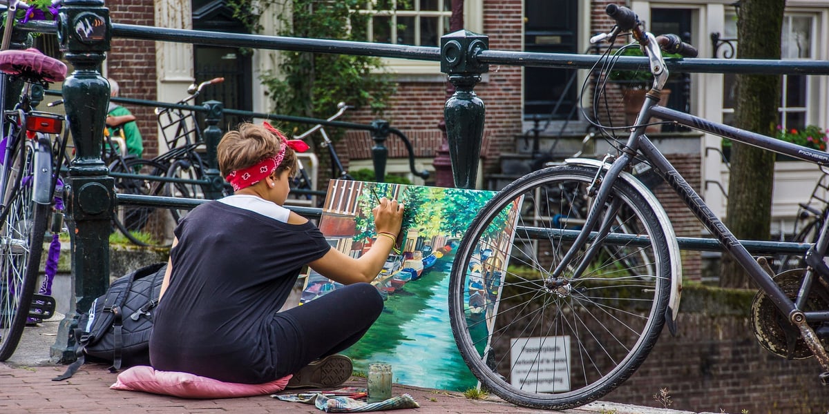 Kobieta malująca na ulicy w Amsterdamie, rowery