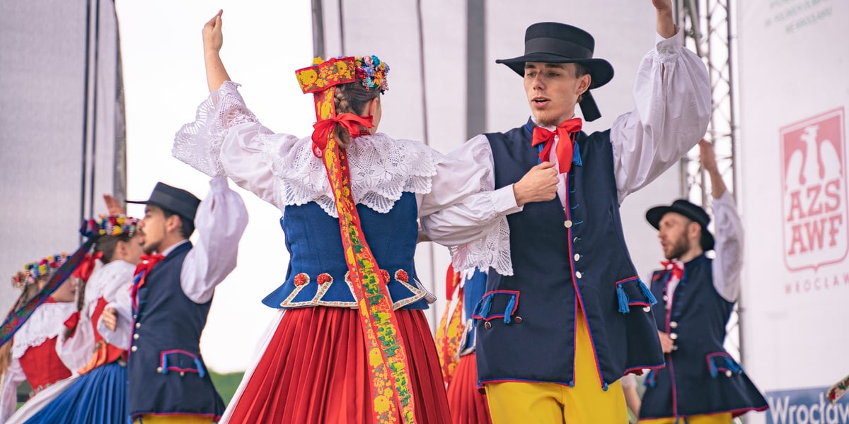 Para ubrana w strój ludowy tańczy na scenie