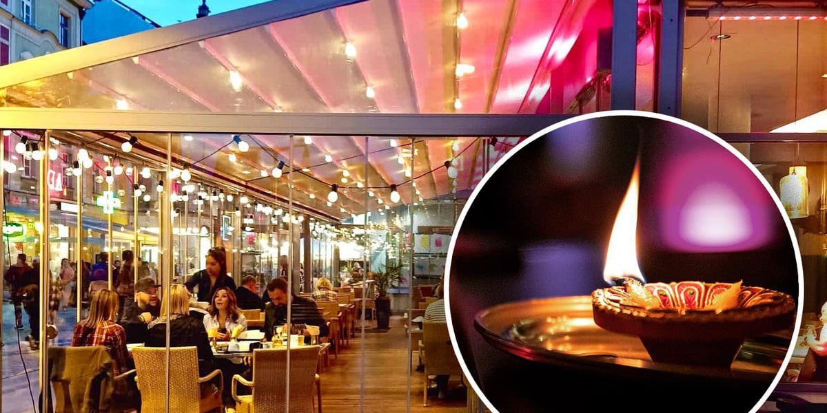 Ogródek zewnętrzny restauracji Masala. Wewnątrz ogródka siedzi przy stolikach dużo ludzi, w środku świecą się kolorowe lampki