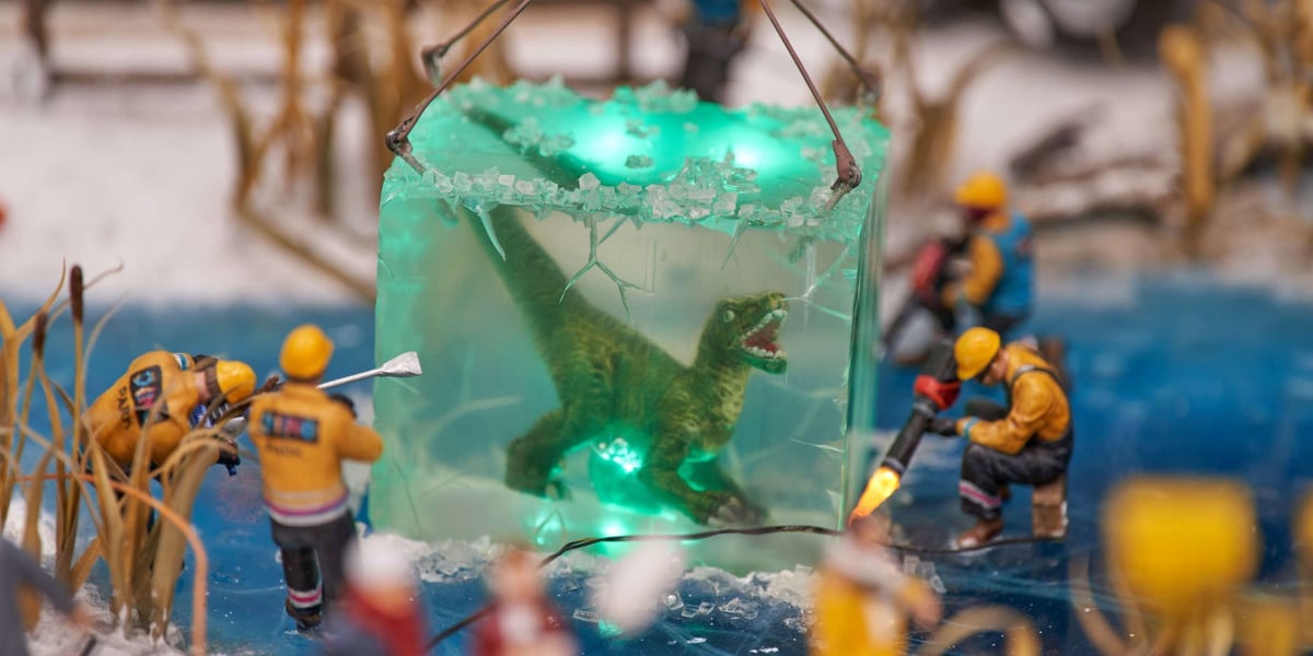Scenka z Kolejkowa: robotnicy wydobyli z zamarzniętego stawu skutego lodem dinozaura. 