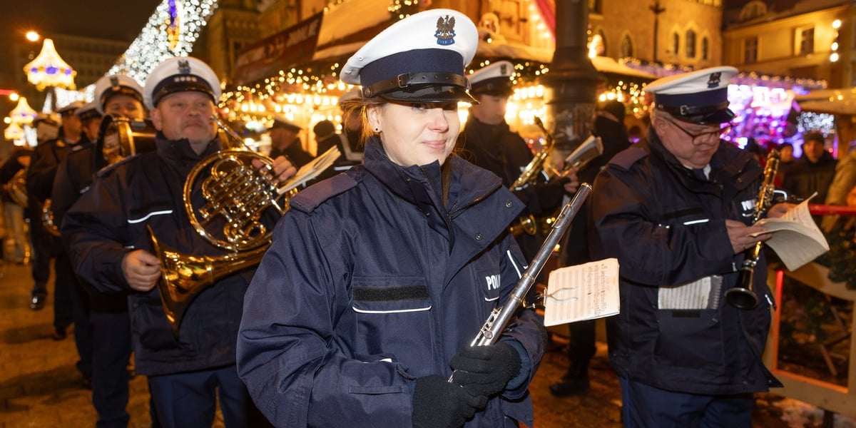 Mężczyźni i kobiety w mundurach policji i z instrumentami muzycznymi w rękach, specjalny występ Orkiestry Komendy Wojewódzkiej Policji we Wrocławiu na Jarmarku Bożonarodzeniowym