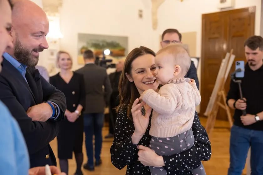 Prezydent Wrocławia Jacek Sutryk (po lewej) podczas konferencji w sprawie zmian w miejskim programie in vitro (15 grudnia 2023 r.). Obok Marta Bułka 8-miesięczną Łucją