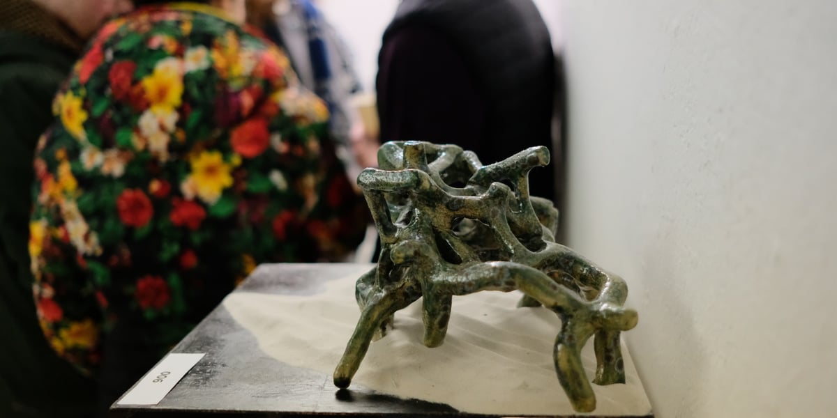 Na postumencie ceramiczna forma przypominająca koralowca. W tle ludzie. Wernisaż wystawy Dno w Galerii u Agatki (11 stycznia 2024)