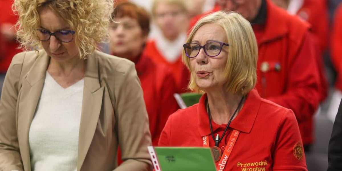 Uroczystości z okazji Międzynarodowego Dnia Przewodnika. Dwie kobiety, po lewej w beżowym żakiecie, po prawej w czerwonej koszulce z napisem "Przewodnik Wrocław"