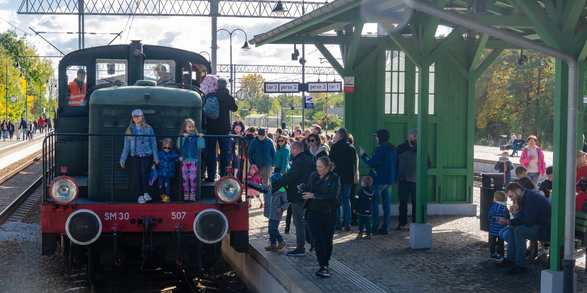 Zabytkowy pociąg na stacji. Widać też ludzi zwiedzających lokomotywę i stojących na peronie