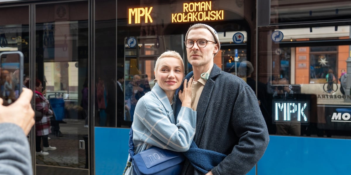 Kobieta i mężczyzna przed tramwajem z napisem Roman Kołakowski