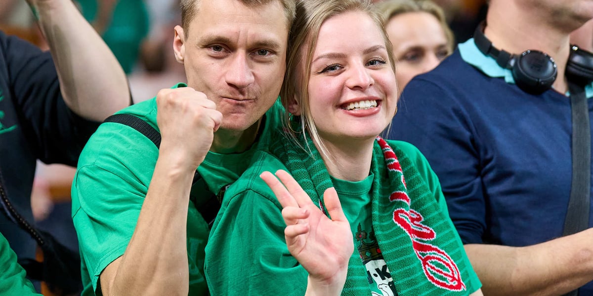 Mężczyzna z zaciśniętą pięścią i kobieta z uniesioną dłonią na meczu Śląska z Anwilem w Hali Stulecia
