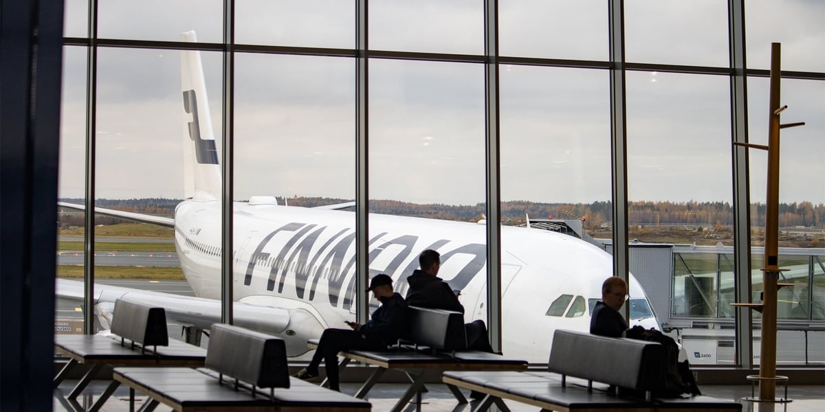 Pasażerowie oczekujący na lotnisku Helsinki-Vantaa i samolot linii Finnair (zdjęcie ilustracyjne)