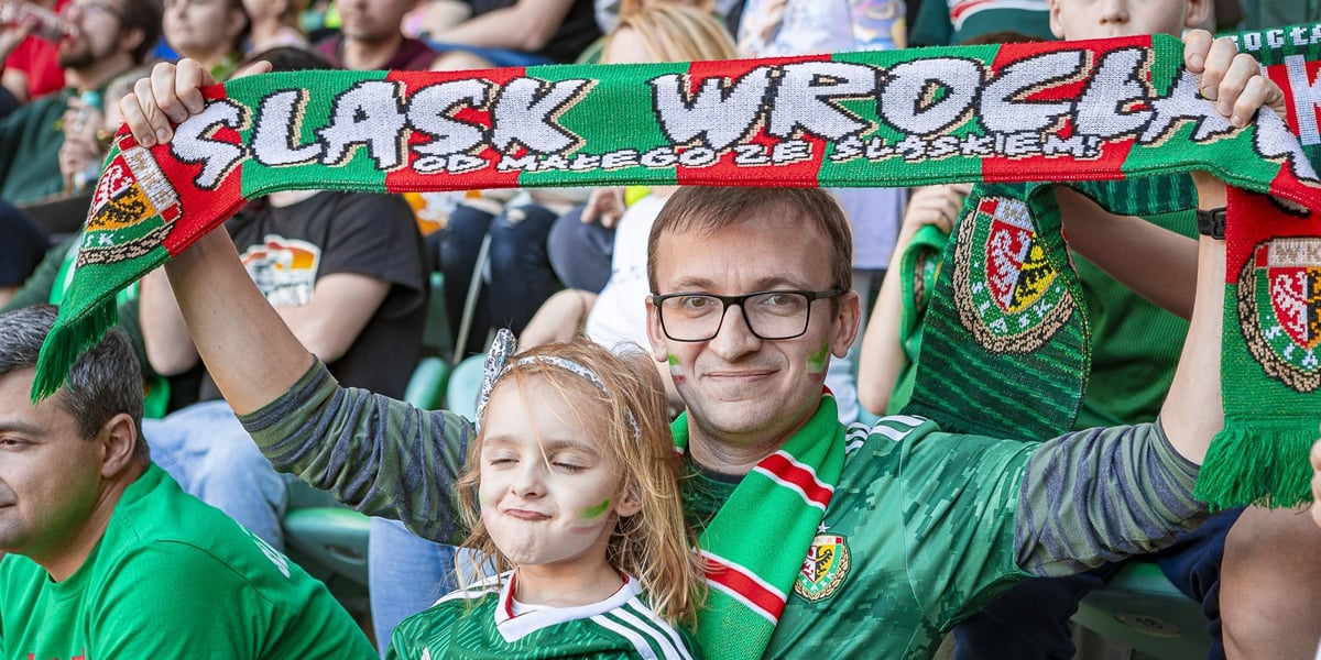 Mężczyzna trzymający nad głową szalik i dziewczynka na meczu Śląska z Ruchem, 27 kwietnia 2024 roku