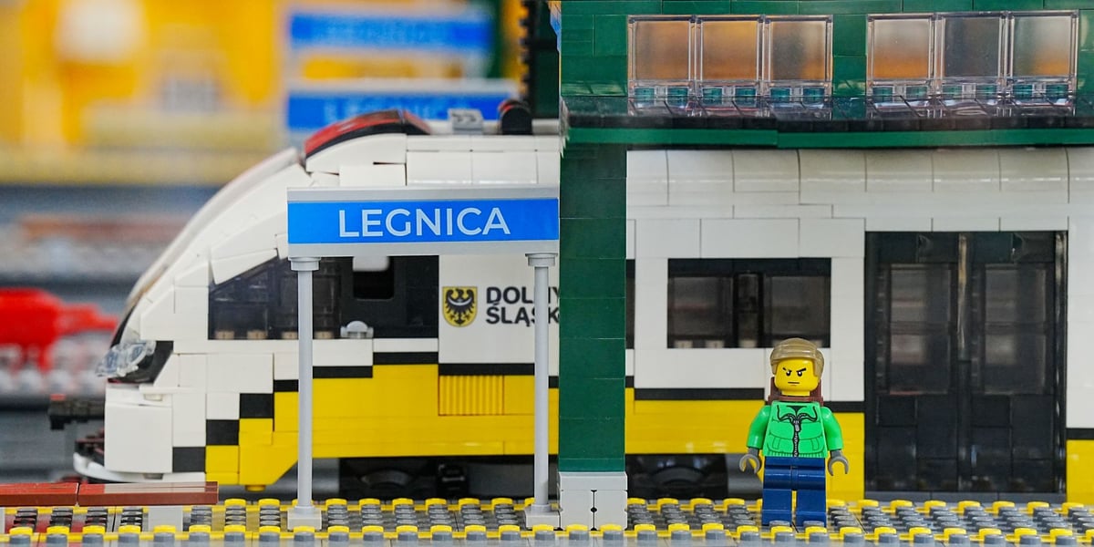 Fragment makiety kolejowej z Lego: widać kawałek stacji Legnica, pociąg i pasażera