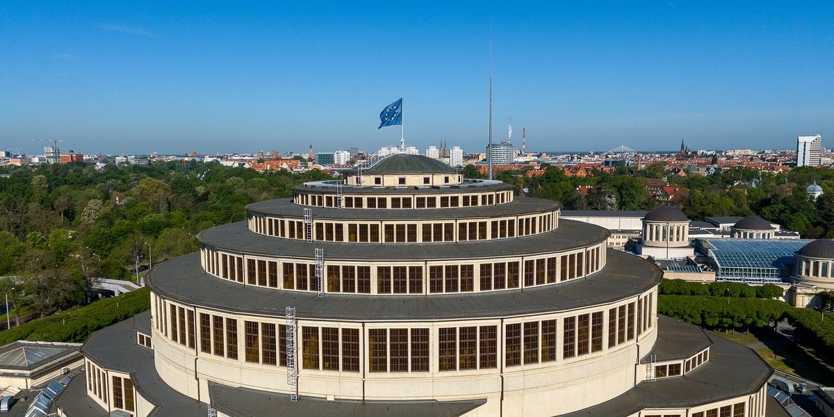 Hala Stulecia. Unijna flaga na szczycie Hali Stulecia, w tle panorama Wrocławia
