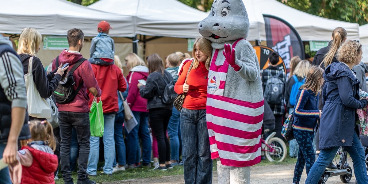Piknik rodzinny. Na zdjęciu dziewczyna przytula się do dużej maskotki