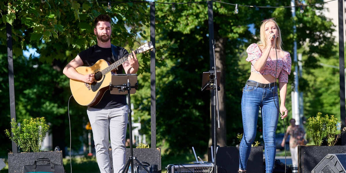 Mężczyzna z gitarą i kobieta z mikrofonem na scenie Przystanku Rondo