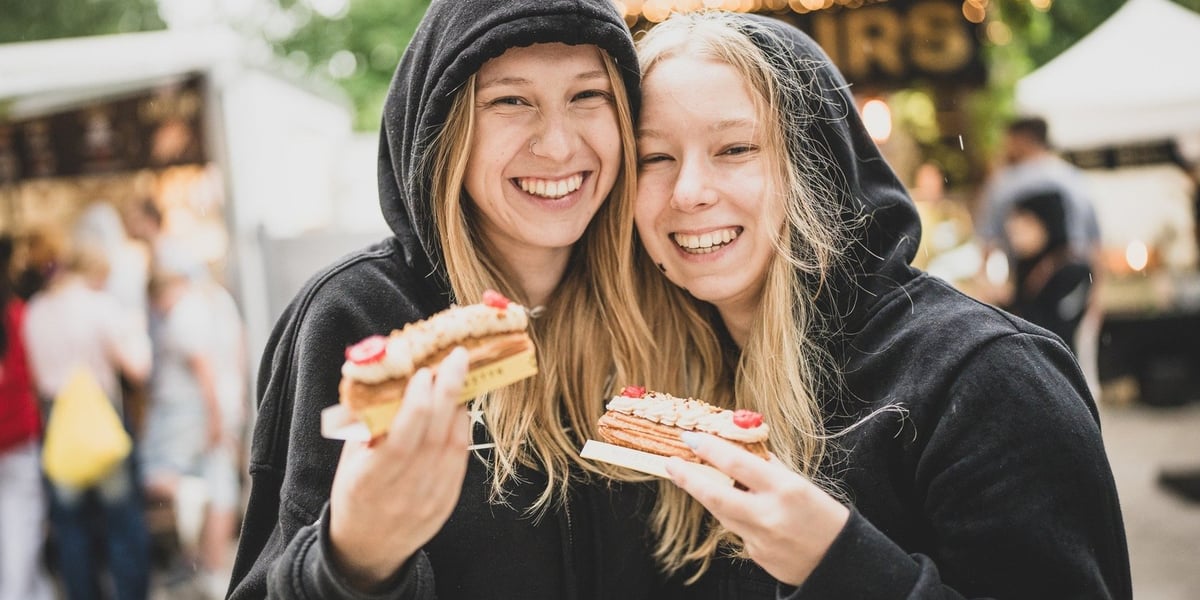 Gastro Miasto na bulwarze Dunikowskiego. Dwie młode, uśmiechnięte kobiety z kanapkami