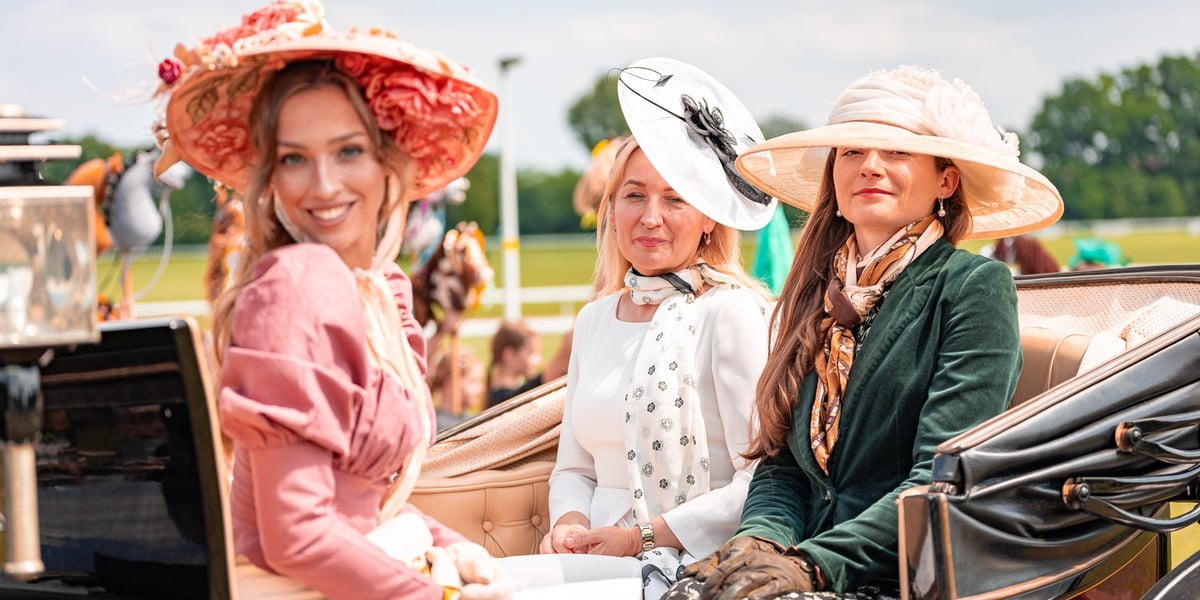 Suempol Ladies Day  na Partynicach. Wrocław, 09.06.2024. Na zdjęciu trzy kobiety w eleganckich strojach siedzące w konnym powozie.