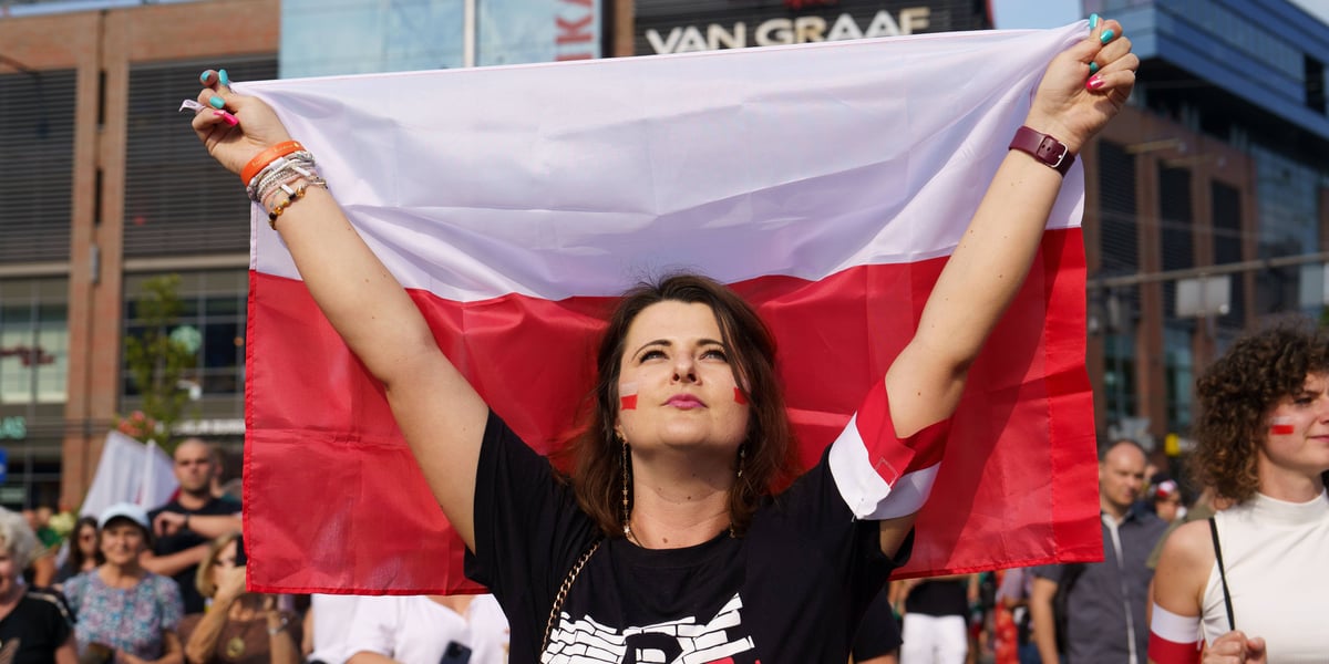 Godzina "W" we Wrocławiu. Jedna z uczestniczek obchodów na pl. Dominikańskim (kobieta trzyma polską flagę) 