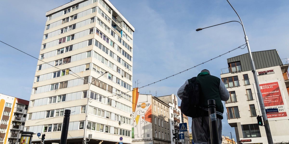 Po prawej stronie zdjęcia jest spacerujący mężczyzna, po lewej Trzonolinowiec 