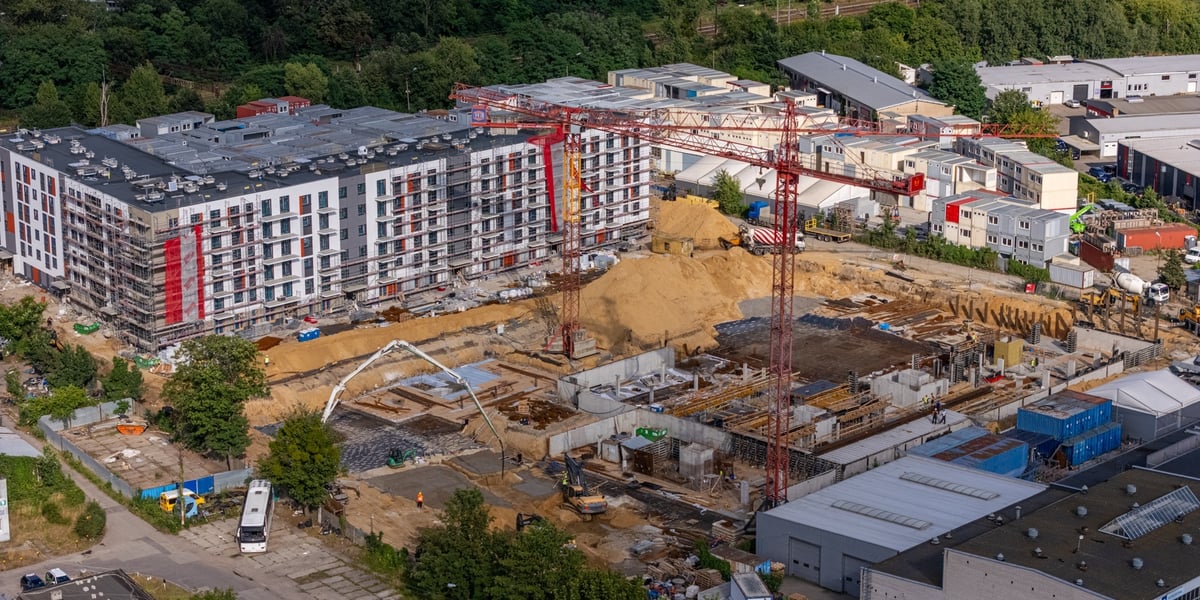 Widok z góry na nowe bloki oraz plac budowy z żurawiem w okolicach ul. Międzyleskiej 