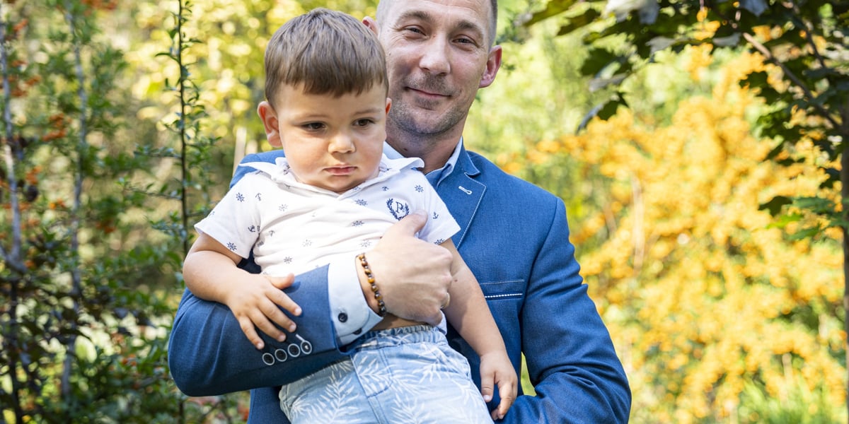 Bohaterski kierowca wrocławskiego MPK - Marcin Krupa trzyma na rękach uratowanego przez siebie chłopca