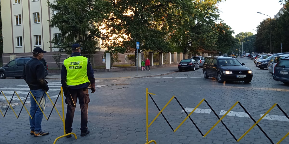 Straż miejska zamyka ulicę i pilnuje przejścia dla pieszych w okolicy szkół podstawowych
