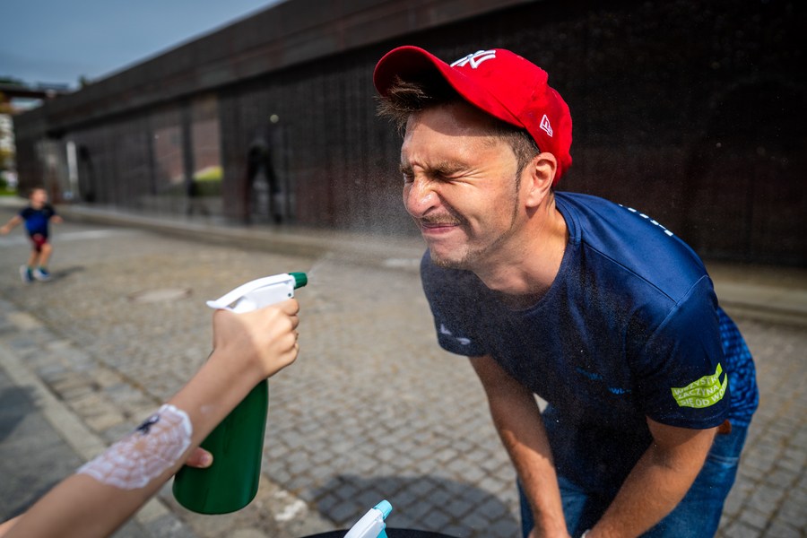 Twarz mężczyzny jest ochlapywana wodą ze spryskiwacza