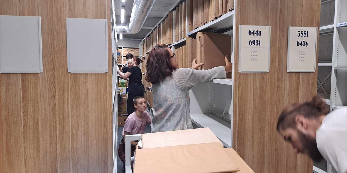 Kobieta i kilka osób pomiędzy regałami z książkami w Archiwum Archidiecezjalnym na Ostrowie Tumskim, 16 września 2024 roku