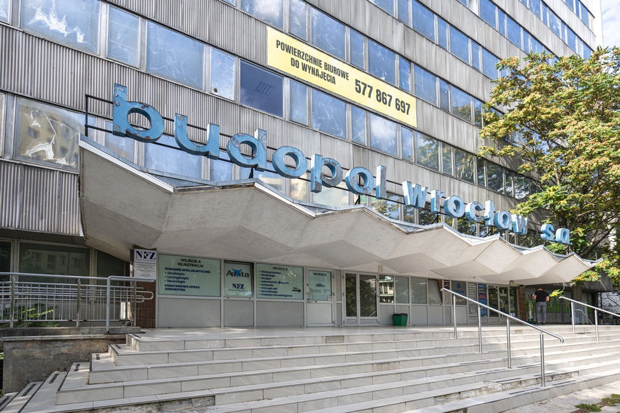 Fragment fasady biurowca Budopolu z zygzakowatym dachem nad wejściem głównym
