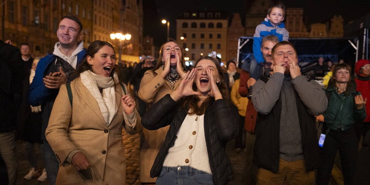 Publiczność na koncercie Wrocław dziękuje, wrocławski rynek, 4 października 2024. Na zdjęciu widać krzyczących i uśmiechniętych  ludzi - kobiety i mężczyzn 