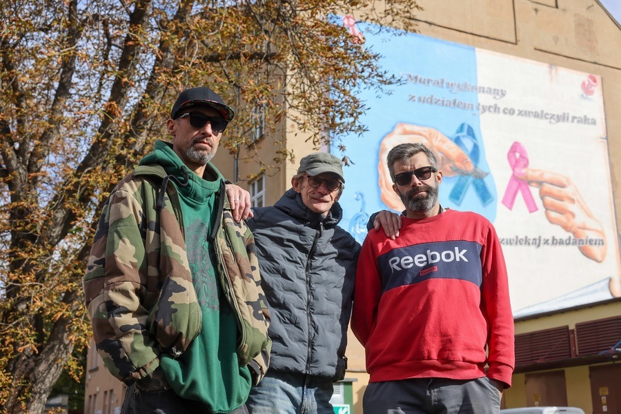 Na tle muralu stoją od lewej: Sebastian Szlachetka, Wojtek Miszewski i Mariusz Sahe