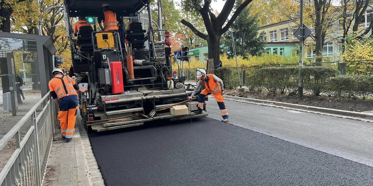 Remont nawierzchni ul. Olszewskiego, układanie masy bitumicznej na wysokości przychodni. Zdjęcie archiwalne