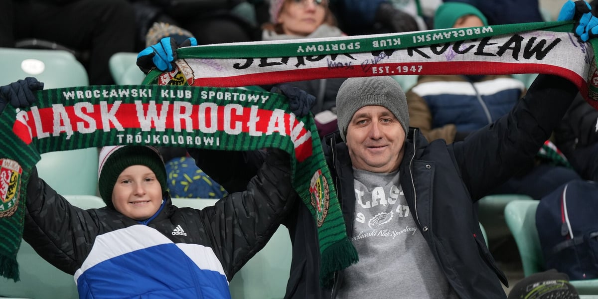 Kibice z szalikami na meczu Śląsk - Radomiak na Tarczyński Arenie, na pierwszym planie z lewej chłopiec, obok mężczyzna