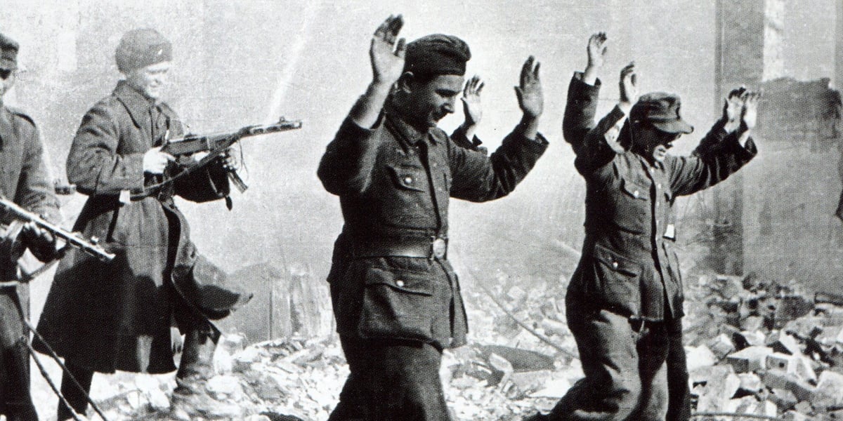 Festung Breslau 1945 . Na archiwalnym zdjęciu widać niemieckich żołnierzy z podniesionymi rękami, którzy są eskortowani przez żołnierzy Armii Czerwonej