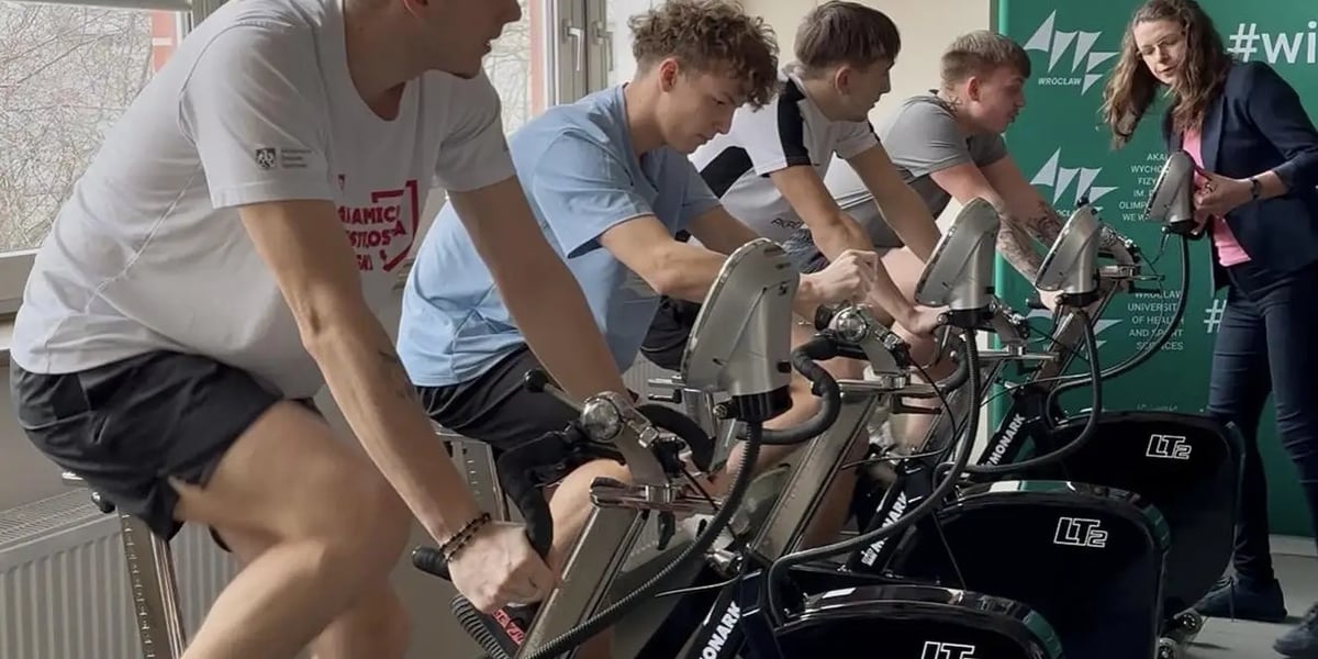 Eksperyment AWF Wrocław z udziałem studentów. Na zdjęciu młodzi mężczyźni na rowerach stacjonarnych