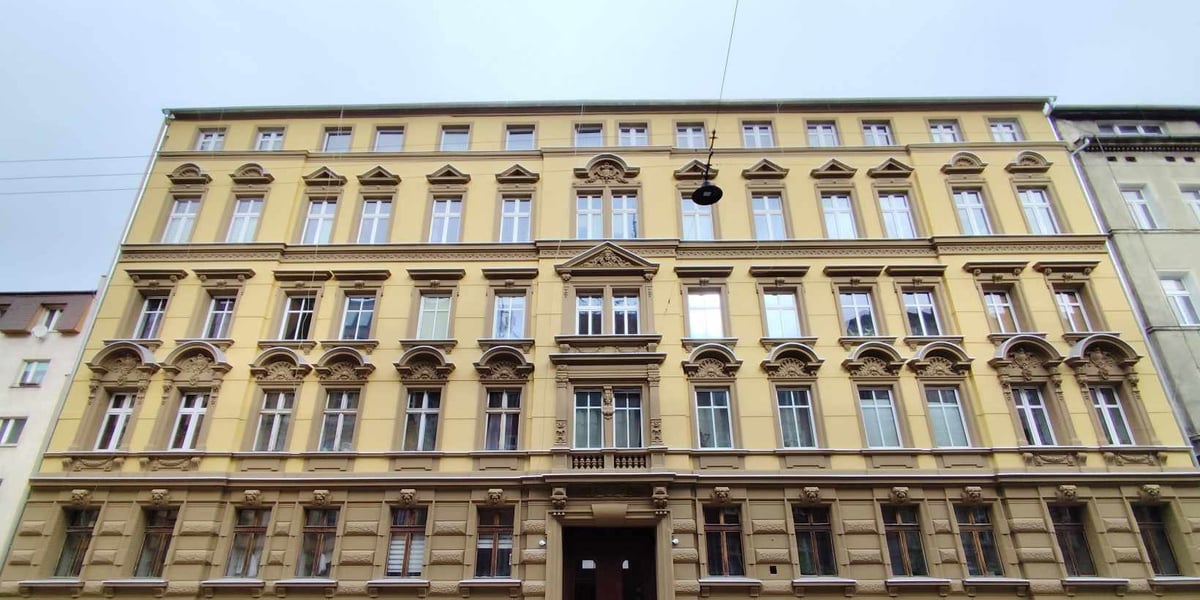 Beżowo-brązowa elewacja wyremontowanej kamienicy przy ul. Komuny Paryskiej we Wrocławiu