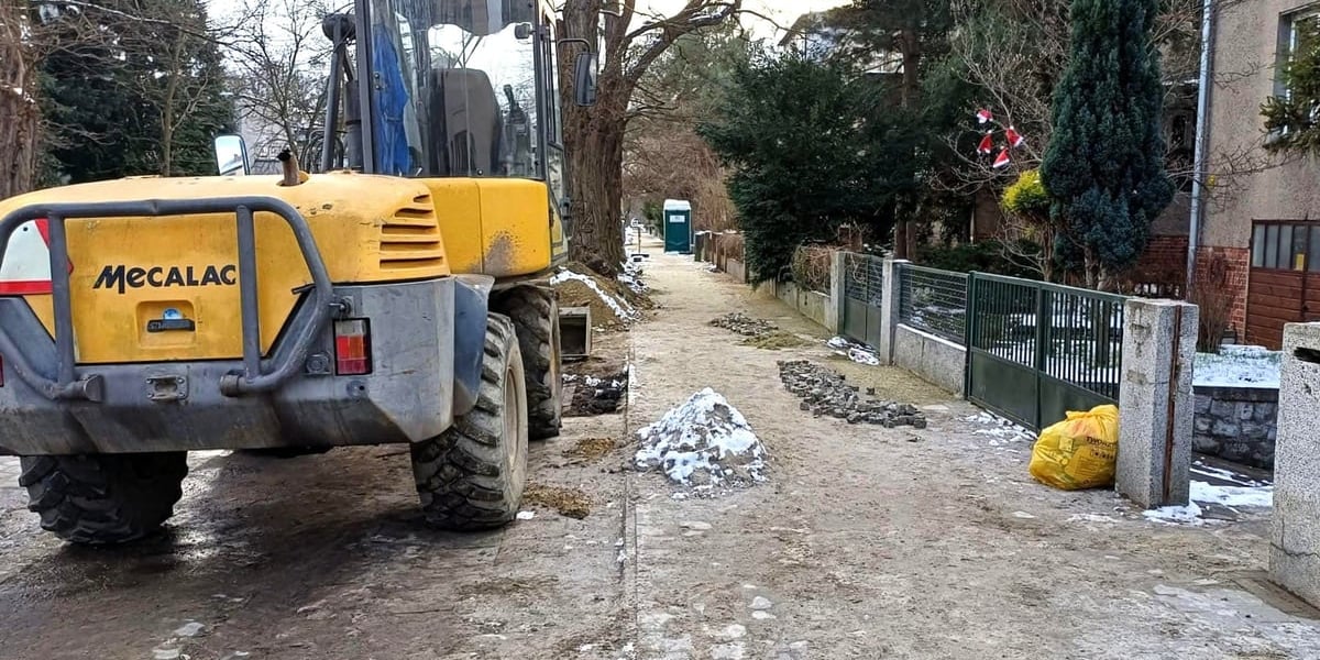 Remont chodnika na ulicy Odkrywców, z lewej żółta koparka 