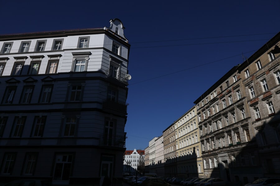 Po lewej stronie kadru widać odnowioną kamienicę Chudoby 15, jej większa część jest w cieniu (marzec 2025)