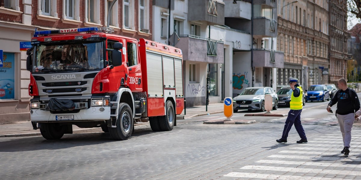 Wóz straży, policjant i pieszy na brukowanej ulicy przy III LO (12 kwietnia 2025)