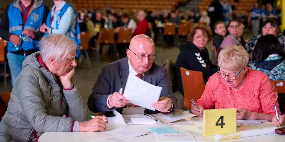 Szkolenie dla członków obwodowych komisji wyborczych we Wrocławiu. Na zdjęciu przy stoliku z dokumentami siedzi kilka osób