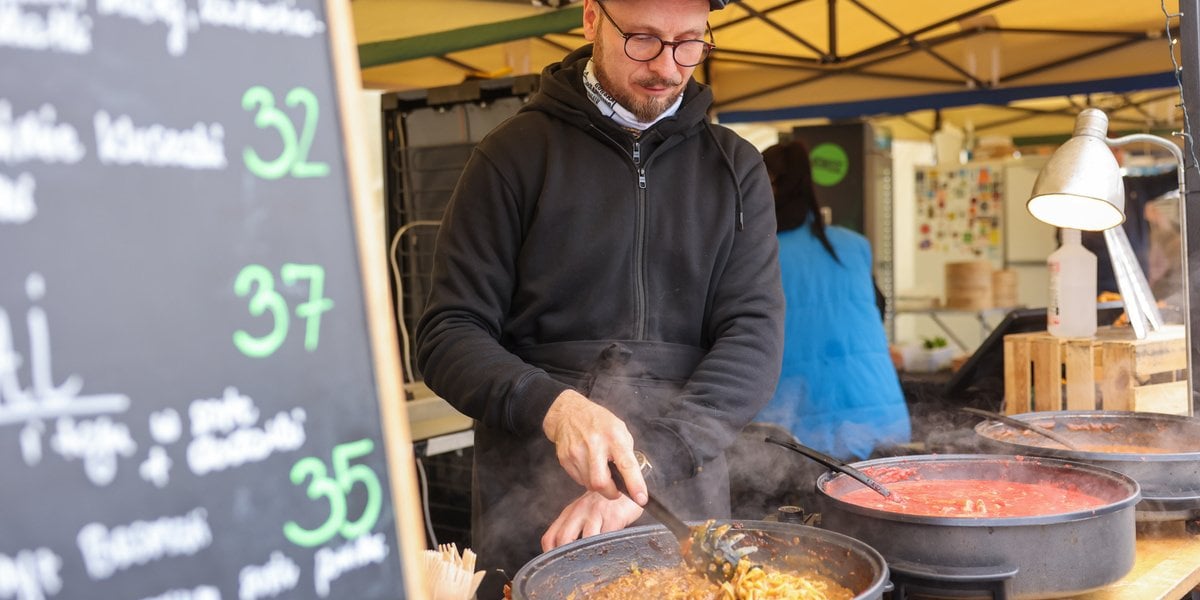 Festiwal Smaków na placu Wolności we Wrocławiu. Na zdjęciu mężczyzna przyrządza jedzenie w wielkiej patelni