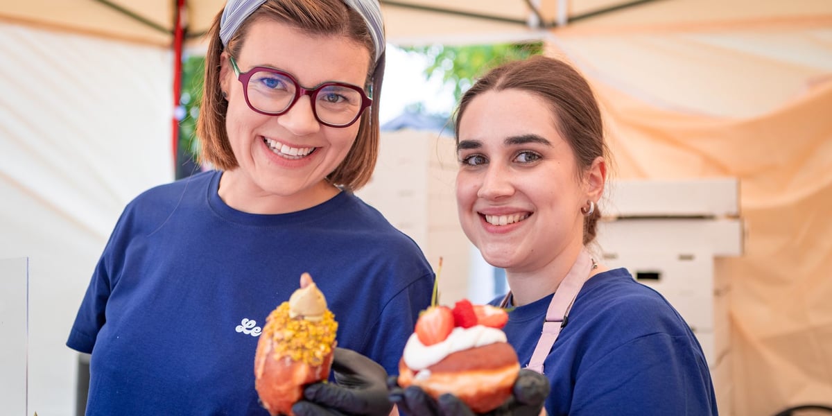 Dwie uśmiechnięte kobiety prezentują słodkie przekąski na Gastro Miasto 2025 