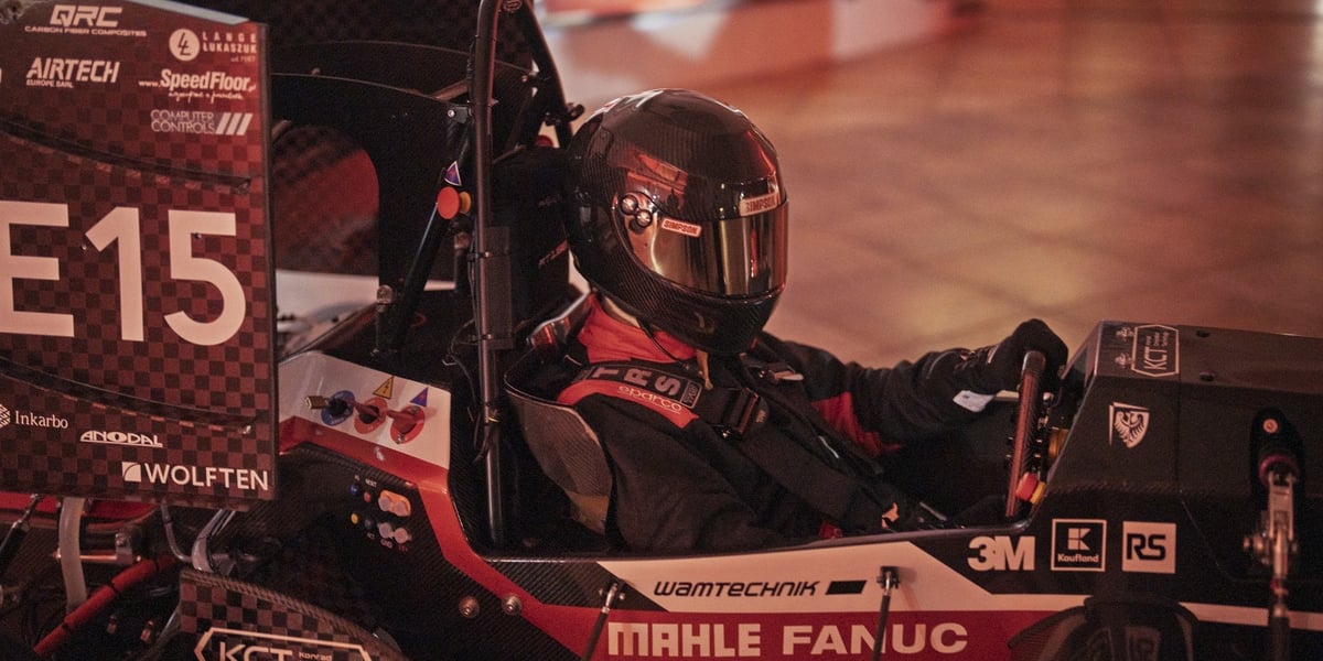 Bolid RT15e skonstruowany przez studentów z PWR Racing Team. Na zdjęciu bolid wyścigowy prowadzony przez kierowcę w stroju kierowcy sportowego
